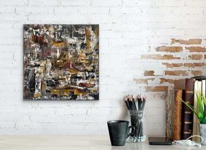 Small abstract painting hung on distressed brick wall